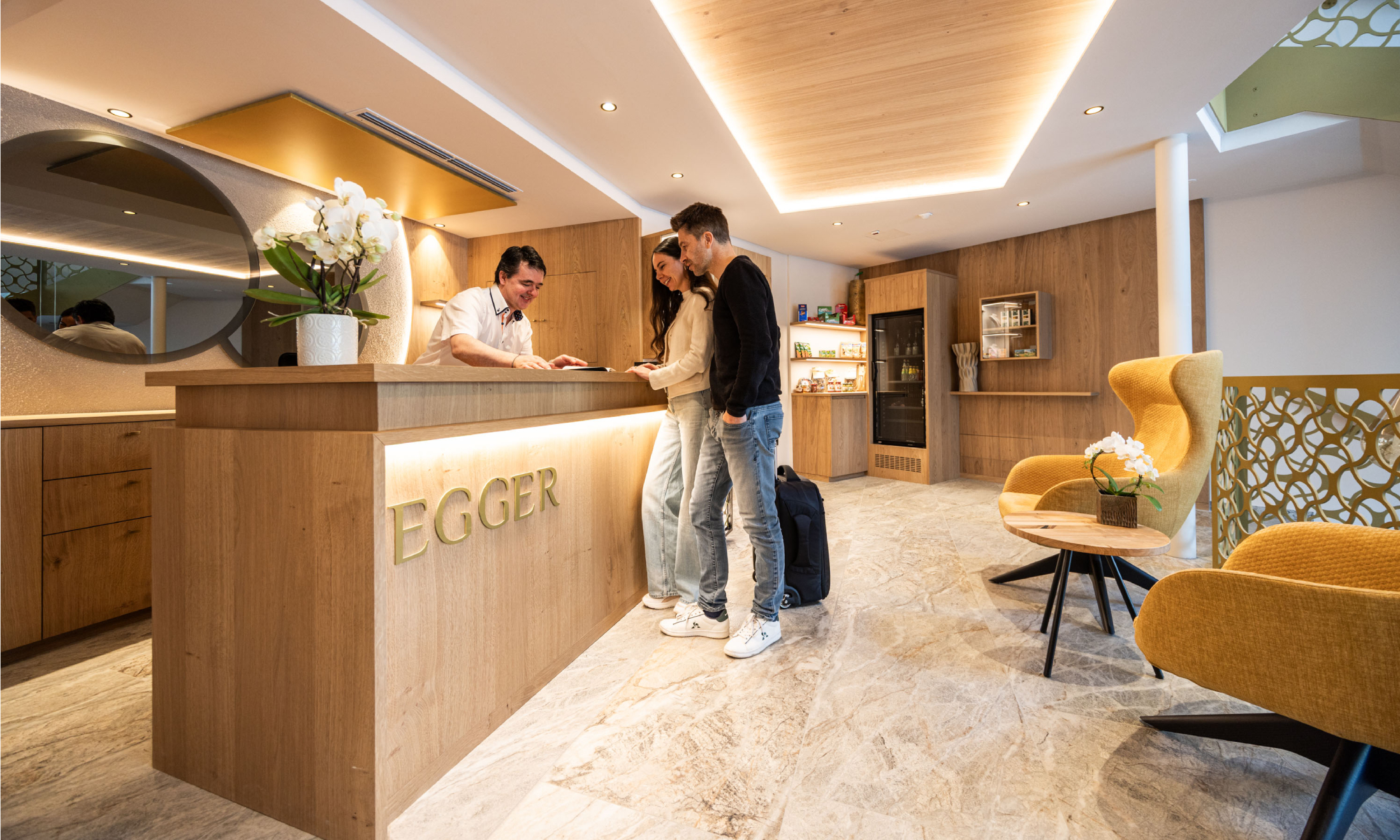 eine Frau und ein Mann werden an der Rezeption begrüßt - Egger Apartments & Suites